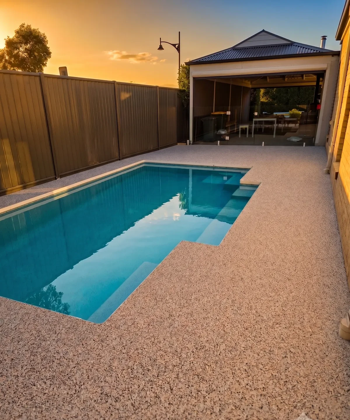 Resin-bound stone pool surround at sunset